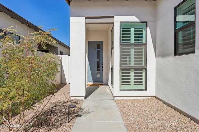 entrance to property featuring stucco siding