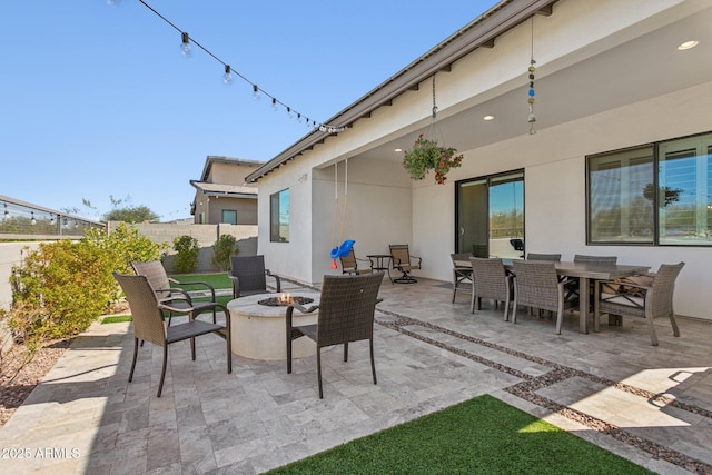 view of patio / terrace with an outdoor fire pit, fence, and outdoor dining area