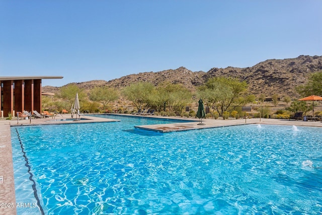 pool featuring a mountain view, a patio, and fence