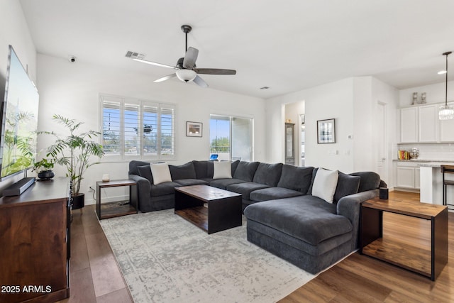 living room featuring a ceiling fan, visible vents, and wood finished floors