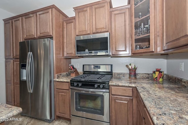 kitchen with light stone counters and appliances with stainless steel finishes