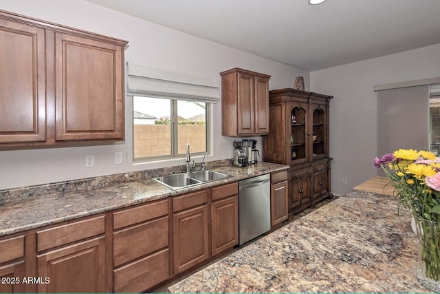 kitchen with dark stone countertops, sink, and dishwasher