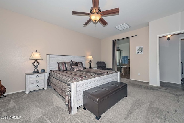 carpeted bedroom with ensuite bath and ceiling fan