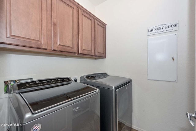 clothes washing area featuring washer and clothes dryer and cabinets