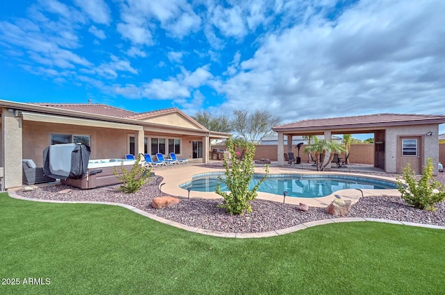 view of pool with a hot tub, a yard, and a patio area