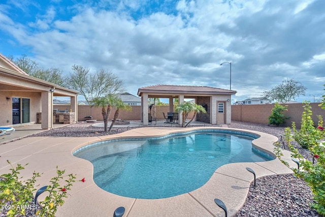 view of swimming pool featuring an outbuilding, a patio area, and an outdoor kitchen