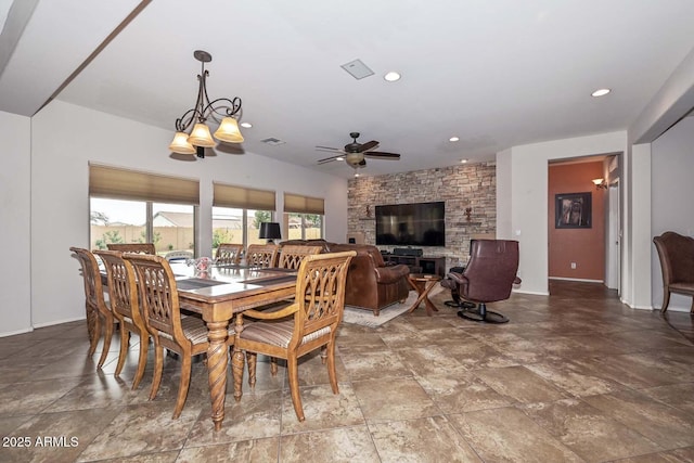 dining area featuring ceiling fan with notable chandelier