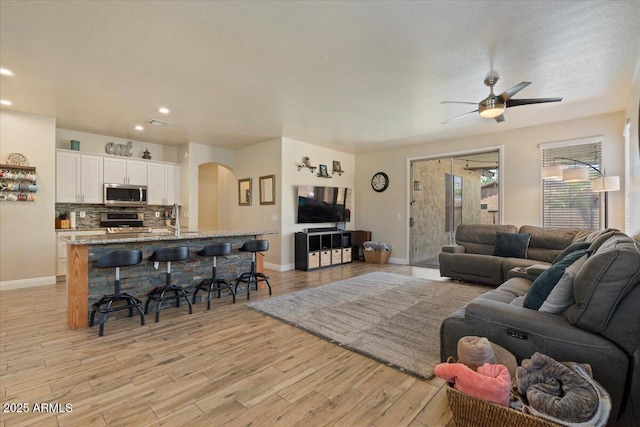 384 N Scott Dr, Chandler, AZ 85225 - living room featuring light wood-style floors, ceiling fan, arched walkways, baseboards, and recessed lighting