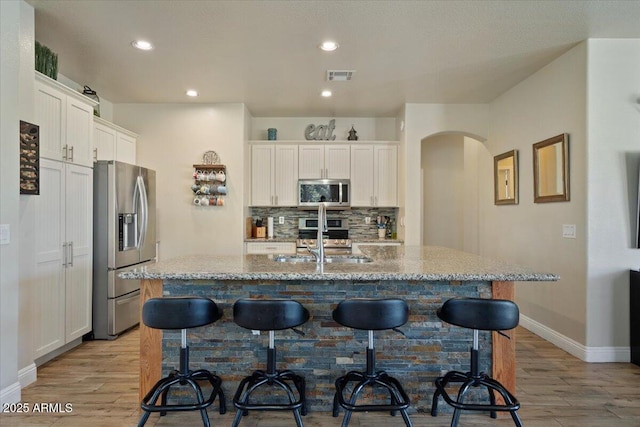 384 N Scott Dr, Chandler, AZ 85225 - kitchen with a breakfast bar area, appliances with stainless steel finishes, visible vents, and light wood-style flooring