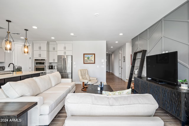 living room featuring sink and dark hardwood / wood-style flooring