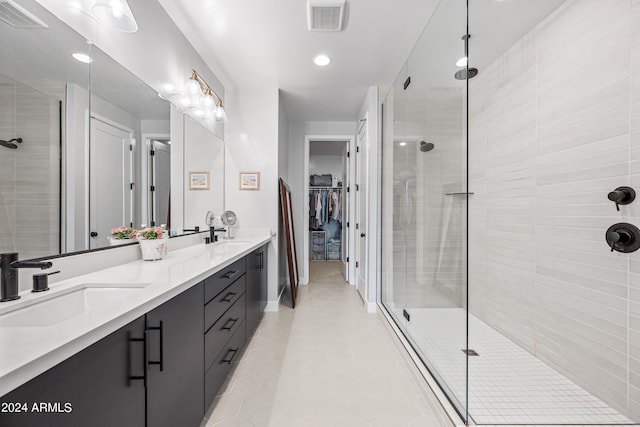 bathroom featuring a shower with shower door, tile patterned flooring, and double vanity