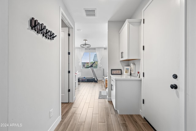 hallway with light hardwood / wood-style floors