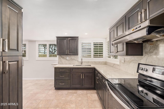 10244 N 65th Ln, Glendale, AZ 85302 - kitchen featuring stainless steel range with electric stovetop, under cabinet range hood, a sink, light countertops, and tasteful backsplash