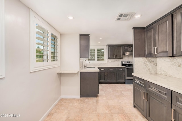 10244 N 65th Ln, Glendale, AZ 85302 - kitchen featuring stainless steel electric range, decorative backsplash, baseboards, under cabinet range hood, and a sink