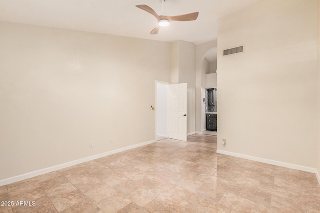 10244 N 65th Ln, Glendale, AZ 85302 - spare room with arched walkways, ceiling fan, a towering ceiling, and baseboards