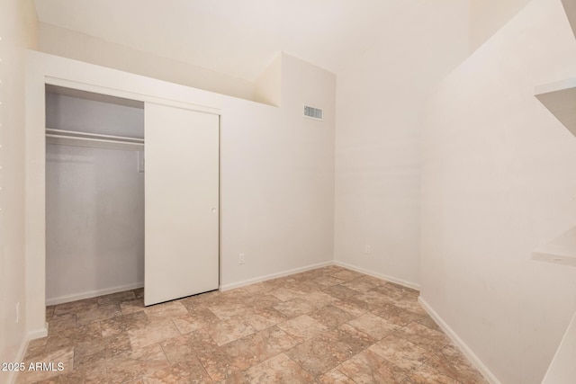 10244 N 65th Ln, Glendale, AZ 85302 - unfurnished bedroom with light stone finish flooring, baseboards, and a closet