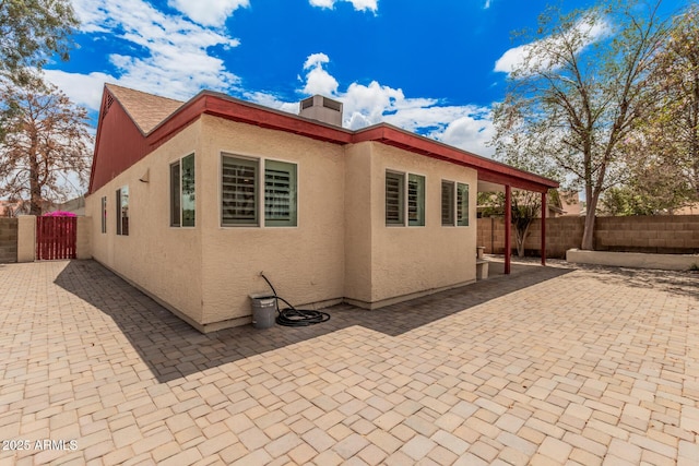 10244 N 65th Ln, Glendale, AZ 85302 - view of property exterior featuring a fenced backyard, a chimney, stucco siding, and a gate