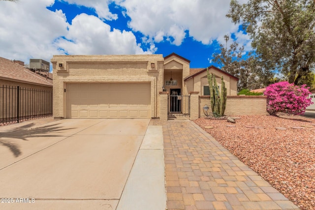 10244 N 65th Ln, Glendale, AZ 85302 - view of front of property with concrete driveway, an attached garage, stucco siding, central AC, and a gate