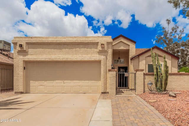 10244 N 65th Ln, Glendale, AZ 85302 - view of front of home featuring stucco siding, concrete driveway, an attached garage, and a gate