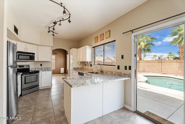 1520 E Flint St, Chandler, AZ 85225 - kitchen with a sink, track lighting, white cabinetry, arched walkways, and appliances with stainless steel finishes