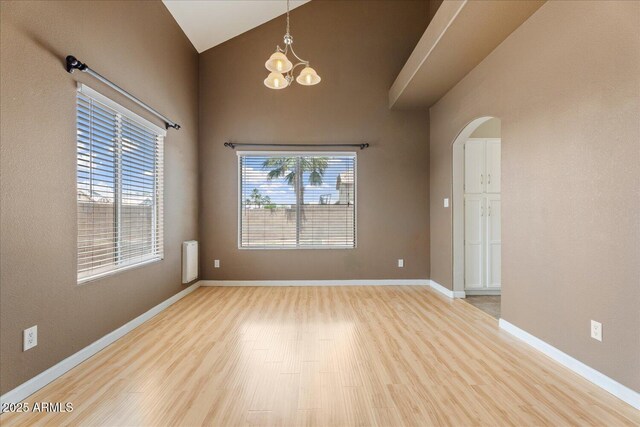 1520 E Flint St, Chandler, AZ 85225 - unfurnished room featuring baseboards, a chandelier, high vaulted ceiling, wood finished floors, and arched walkways