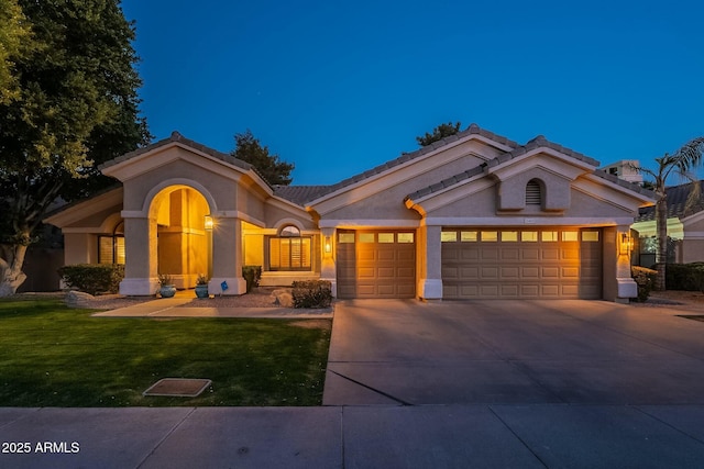 mediterranean / spanish house with a garage and a yard