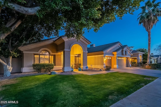 mediterranean / spanish-style house featuring a garage and a front lawn