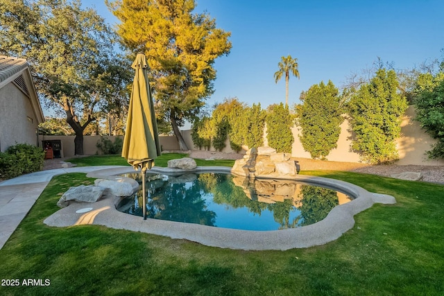 view of pool featuring a lawn