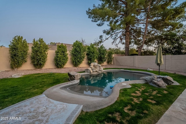 view of swimming pool featuring a yard