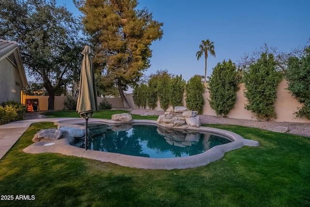 view of pool with a yard