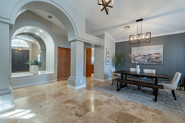 dining space featuring crown molding, a chandelier, and ornate columns