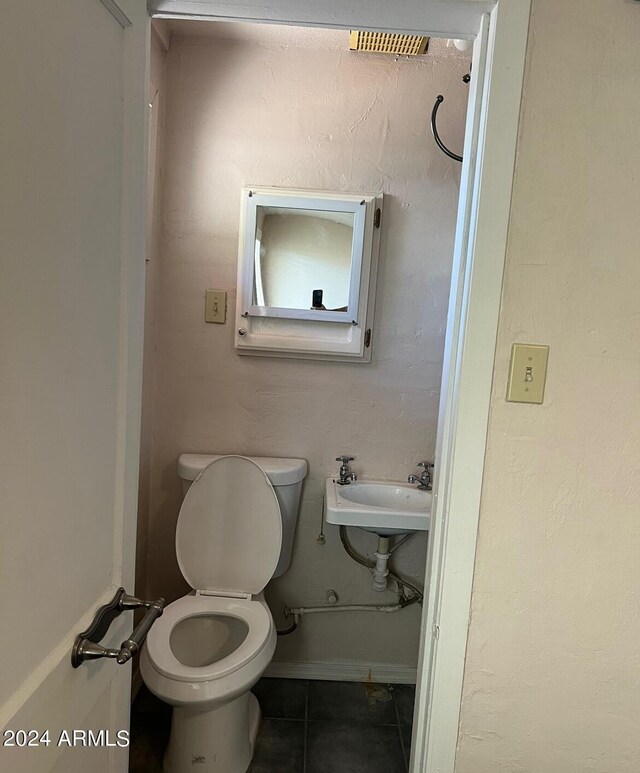 bathroom featuring tile patterned floors, baseboards, a sink, and toilet