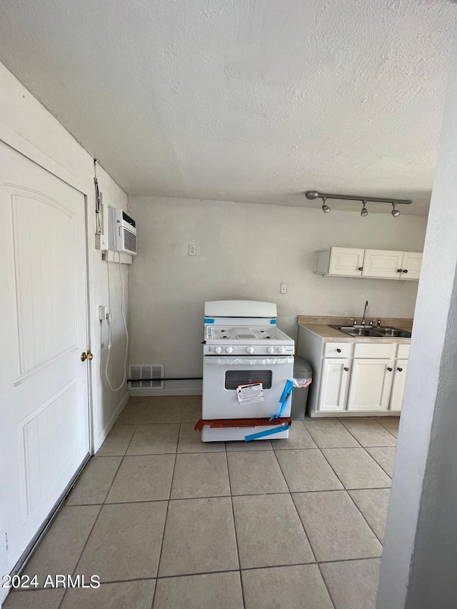 kitchen with visible vents, white gas stove, a sink, and a textured ceiling