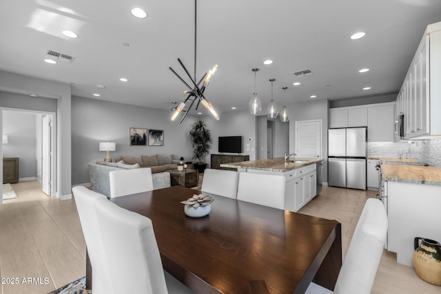 dining area featuring sink and a chandelier