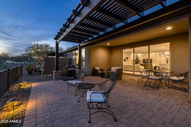 patio terrace at dusk featuring grilling area and a pergola