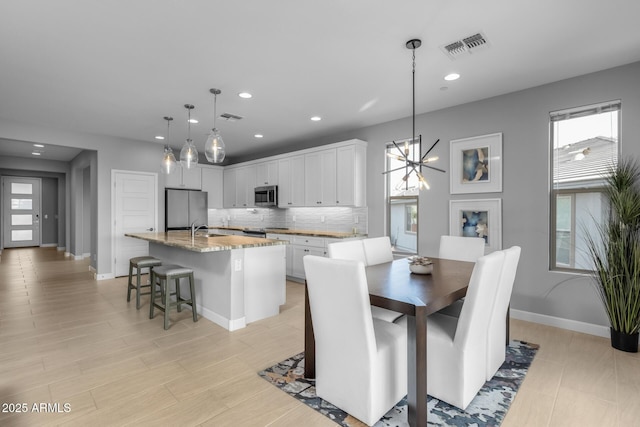 dining room with sink and a notable chandelier