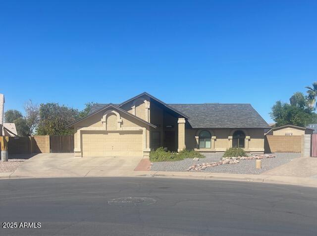 ranch-style house featuring driveway, an attached garage, and stucco siding