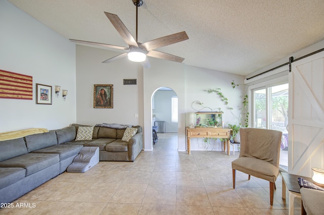 5424 E Florian Ave, Mesa, AZ 85206 - living area featuring vaulted ceiling, arched walkways, a ceiling fan, light tile patterned floors, and a barn door