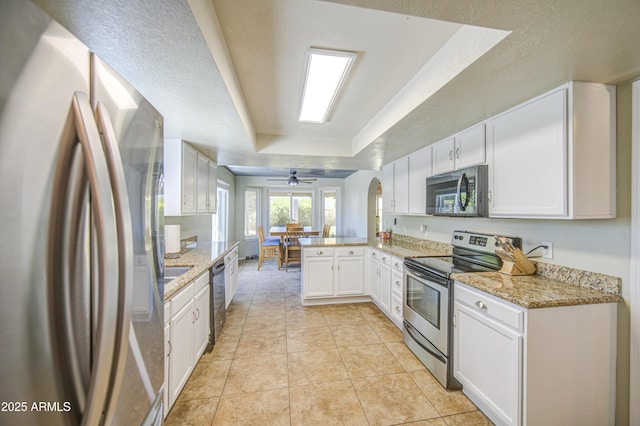 5424 E Florian Ave, Mesa, AZ 85206 - kitchen with stainless steel appliances, a peninsula, a raised ceiling, white cabinets, and light stone countertops