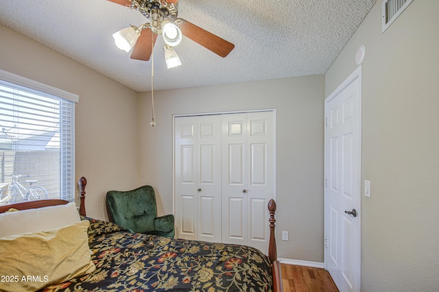 5424 E Florian Ave, Mesa, AZ 85206 - bedroom featuring wood finished floors, a closet, a textured ceiling, ceiling fan, and baseboards