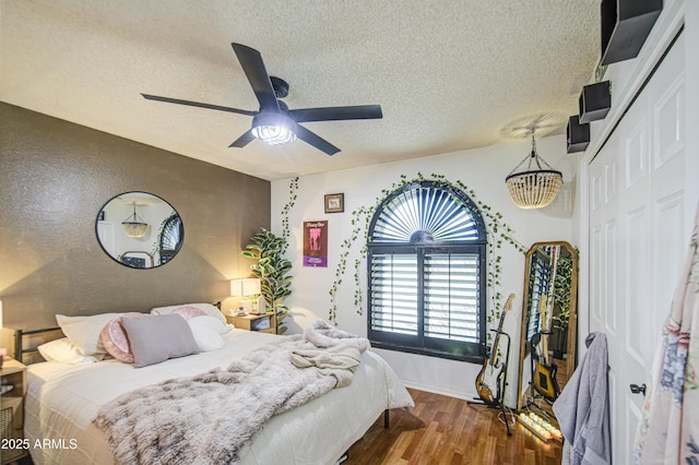 5424 E Florian Ave, Mesa, AZ 85206 - bedroom featuring a textured ceiling, wood finished floors, a closet, ceiling fan, and baseboards