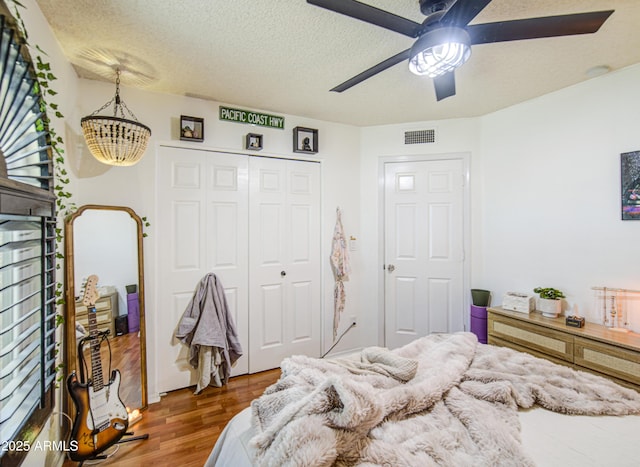 5424 E Florian Ave, Mesa, AZ 85206 - bedroom with wood finished floors, a closet, a chandelier, ceiling fan, and a textured ceiling