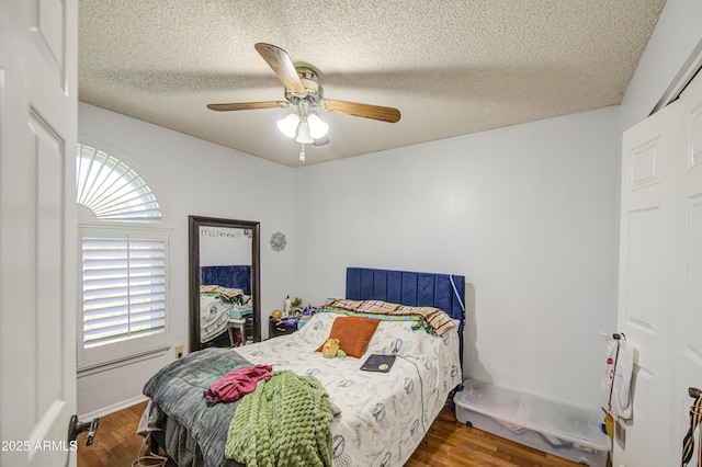 5424 E Florian Ave, Mesa, AZ 85206 - bedroom featuring wood finished floors, multiple windows, a textured ceiling, and a ceiling fan