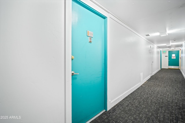 corridor with carpet flooring, visible vents, and baseboards