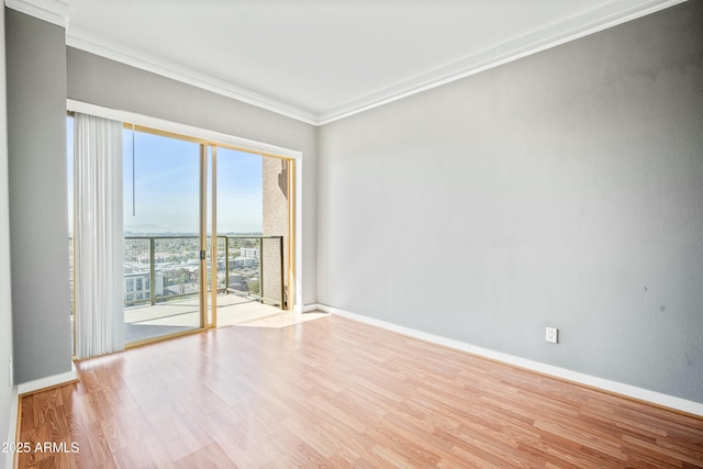 unfurnished room with baseboards, wood finished floors, and ornamental molding