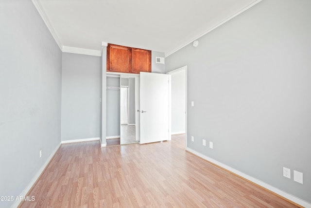 unfurnished bedroom with visible vents, ornamental molding, light wood-style flooring, and baseboards