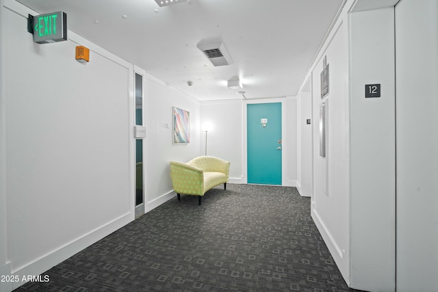 hallway featuring carpet, visible vents, and baseboards