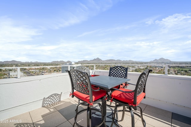 balcony with outdoor dining space and a mountain view