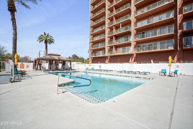community pool featuring fence, a gazebo, and a patio