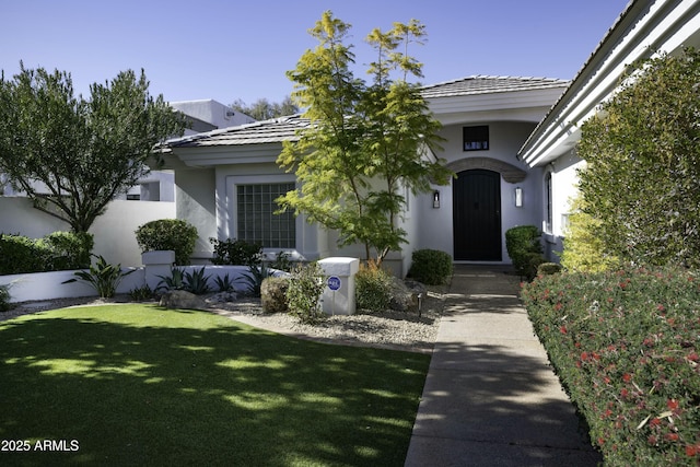 doorway to property with a lawn